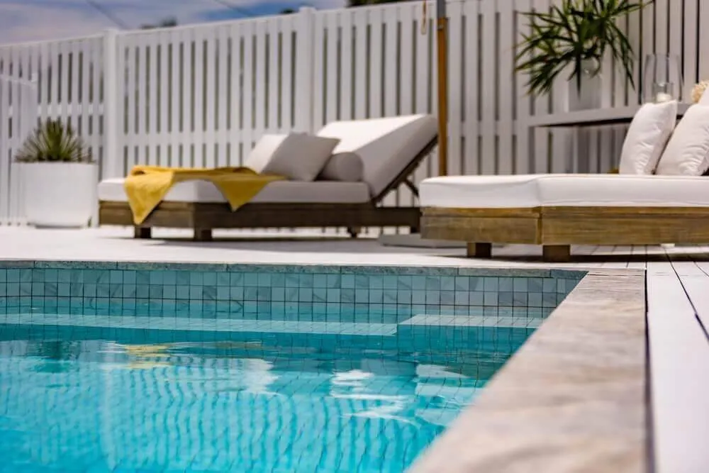 Rectangular plunge pool beside a deck with outdoor lounges