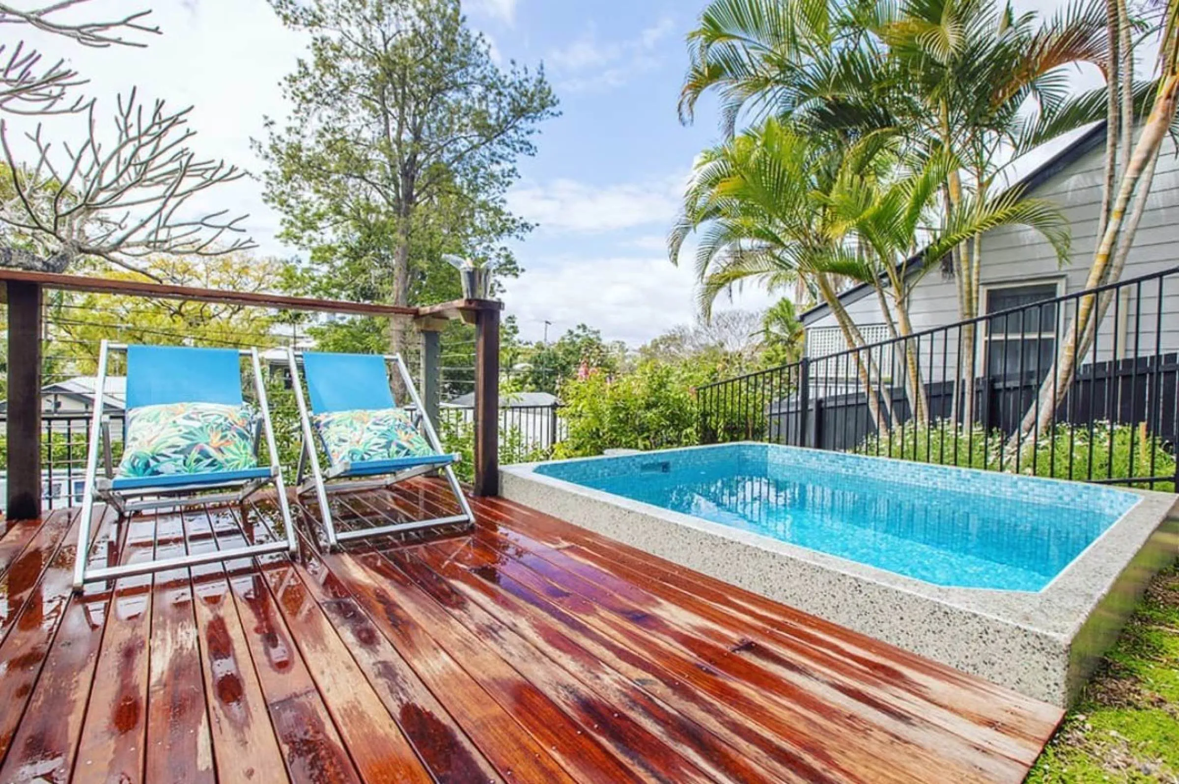 Rectangular plunge pool set into a timber deck with two deck chairs