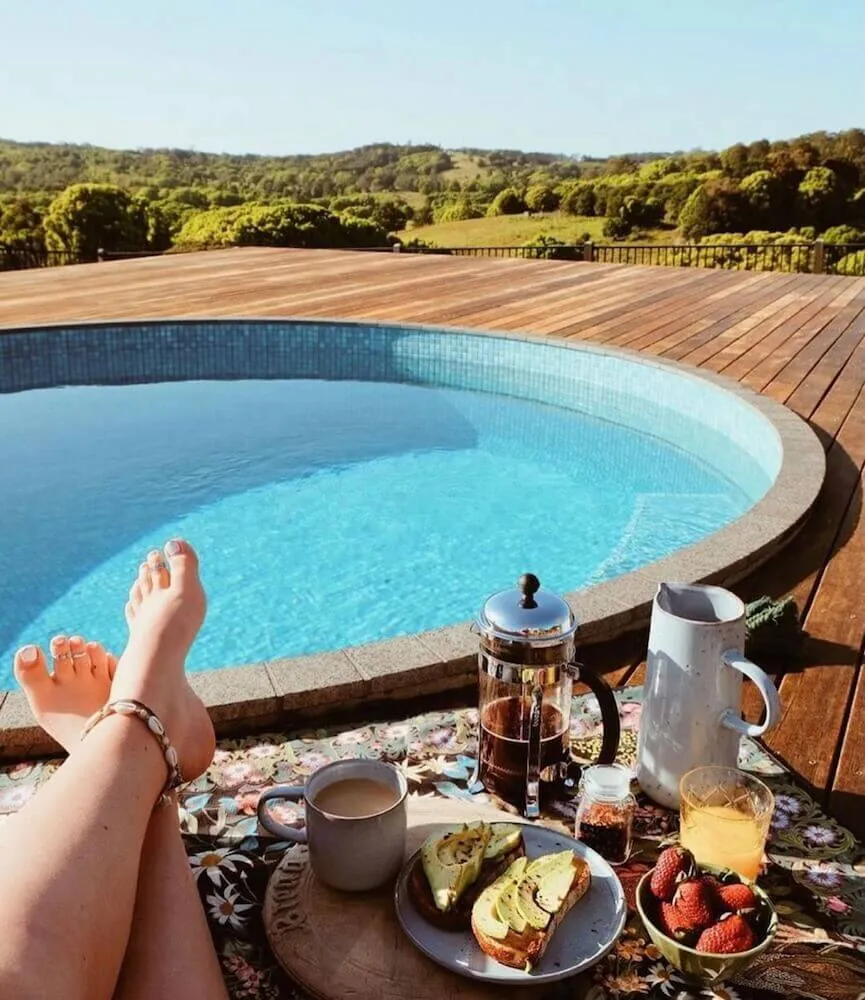 Breakfast laid out beside a round plunge pool set into a timber deck