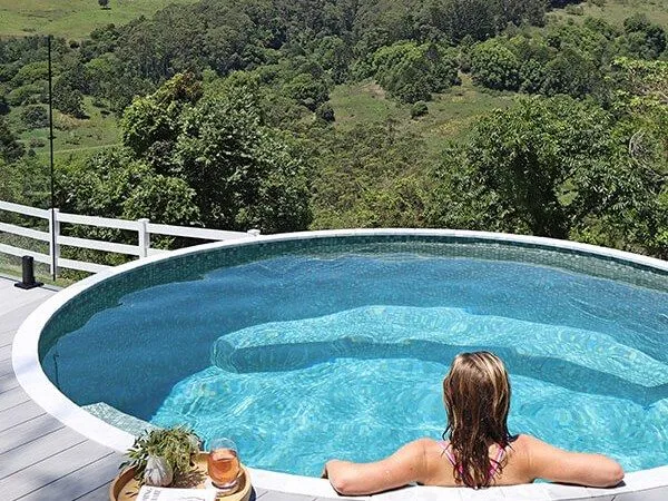 The Eden round plunge pool with a person relaxing at the edge