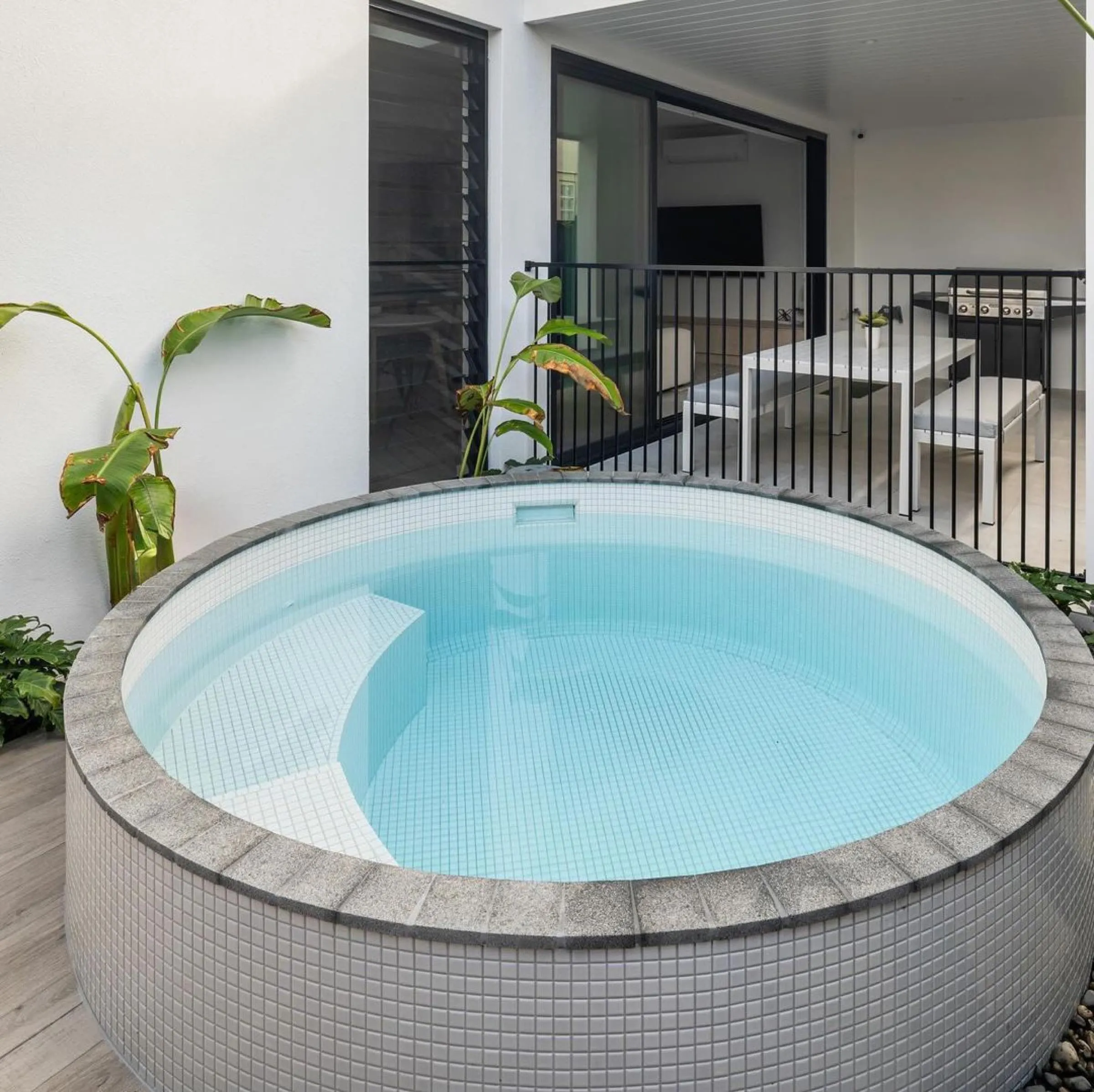 Round tiled plunge pool on a deck outside a townhouse
