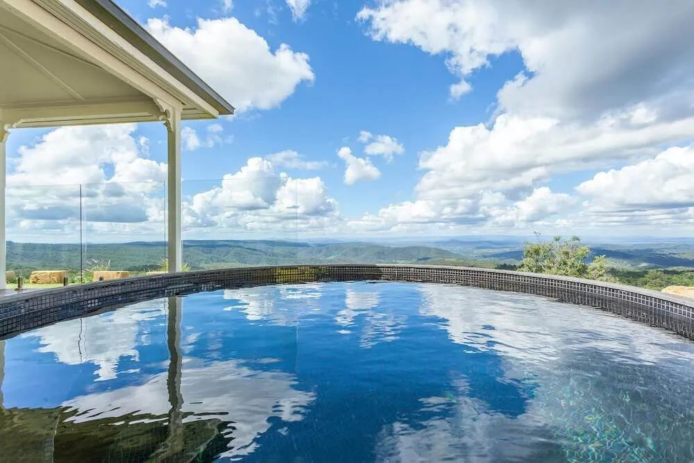 Round plunge pool reflecting the clouds, with valley views