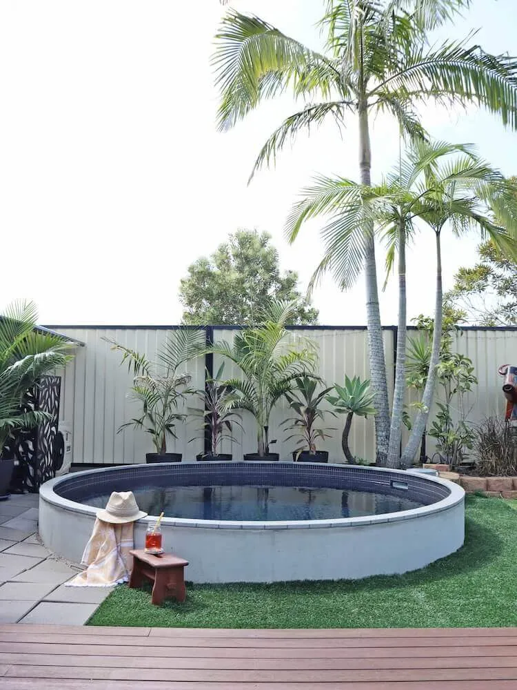 Round plunge pool on turf beside palms