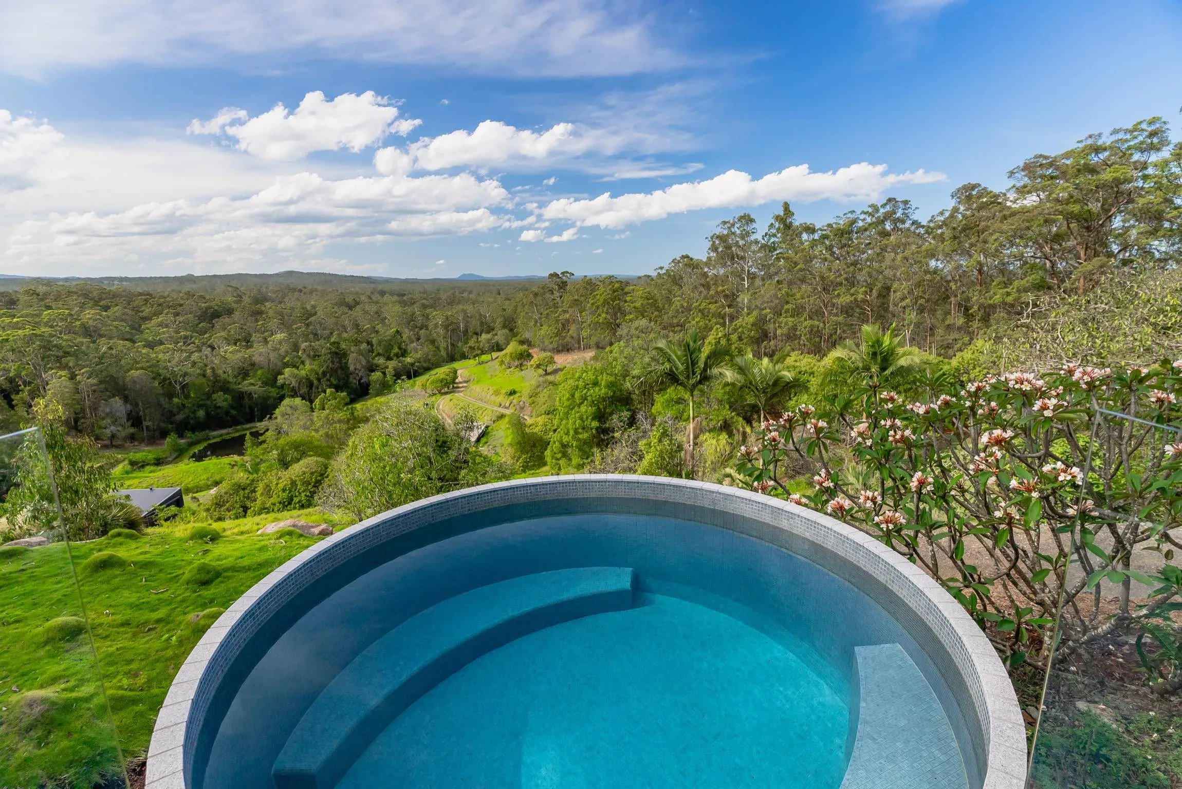 Round plunge pool with a tiled seat looking out over the valley