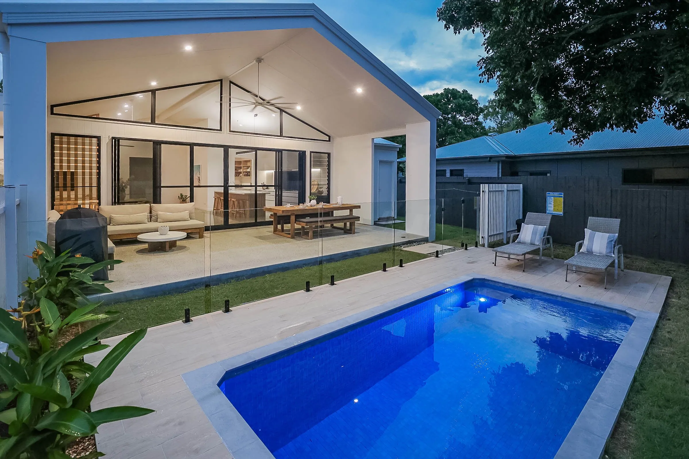 Rectangular plunge pool beside a paved alfresco area with sun lounges
