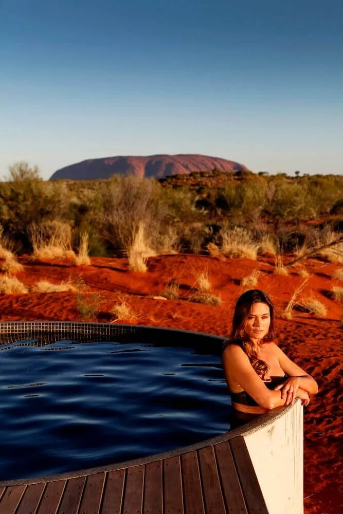 Woman in a round plunge pool on a deck in the outback