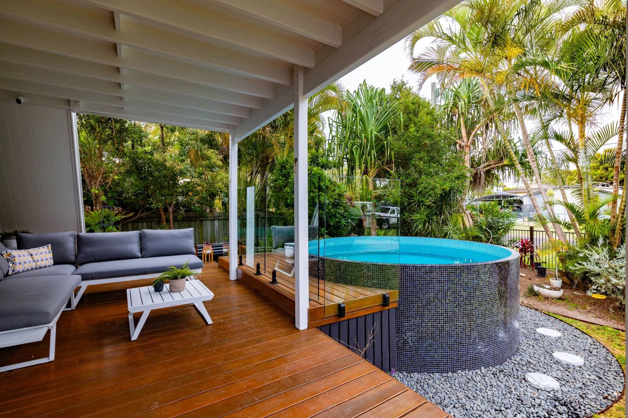 Round plunge pool beside a covered timber deck and outdoor lounge