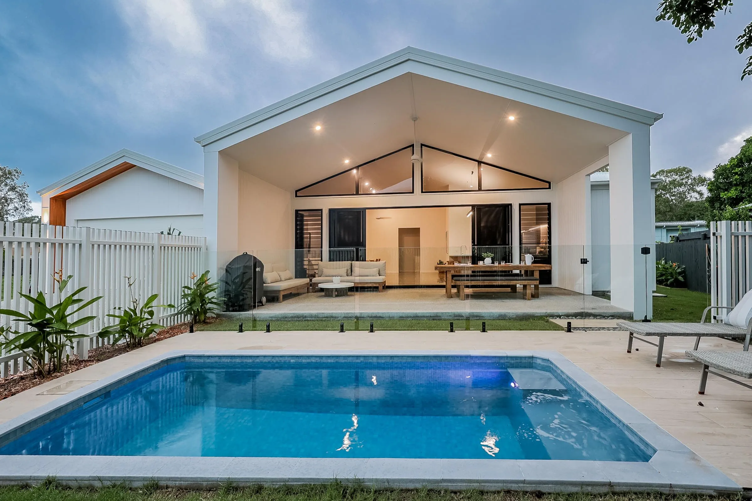 Rectangular plunge pool in front of a modern home's alfresco area