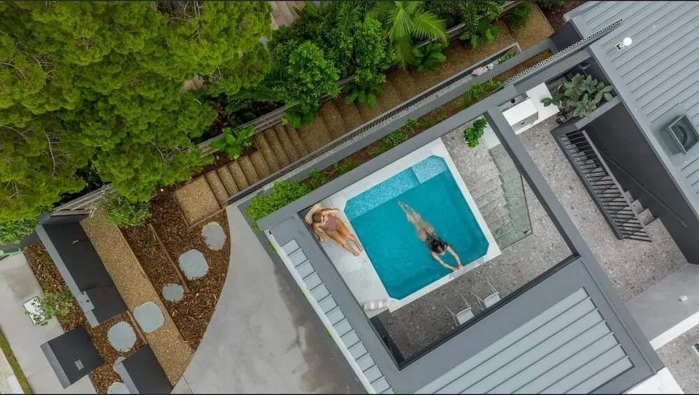 Aerial view of a person swimming in a square plunge pool