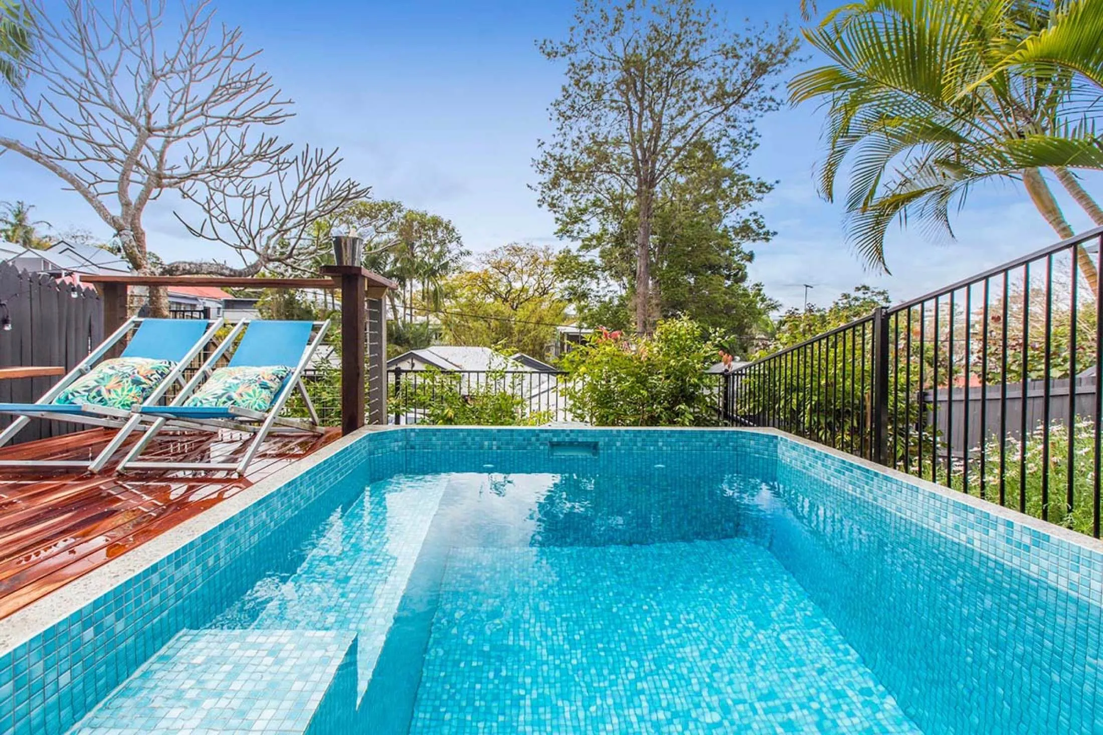 Rectangular mosaic-tiled plunge pool on an elevated deck
