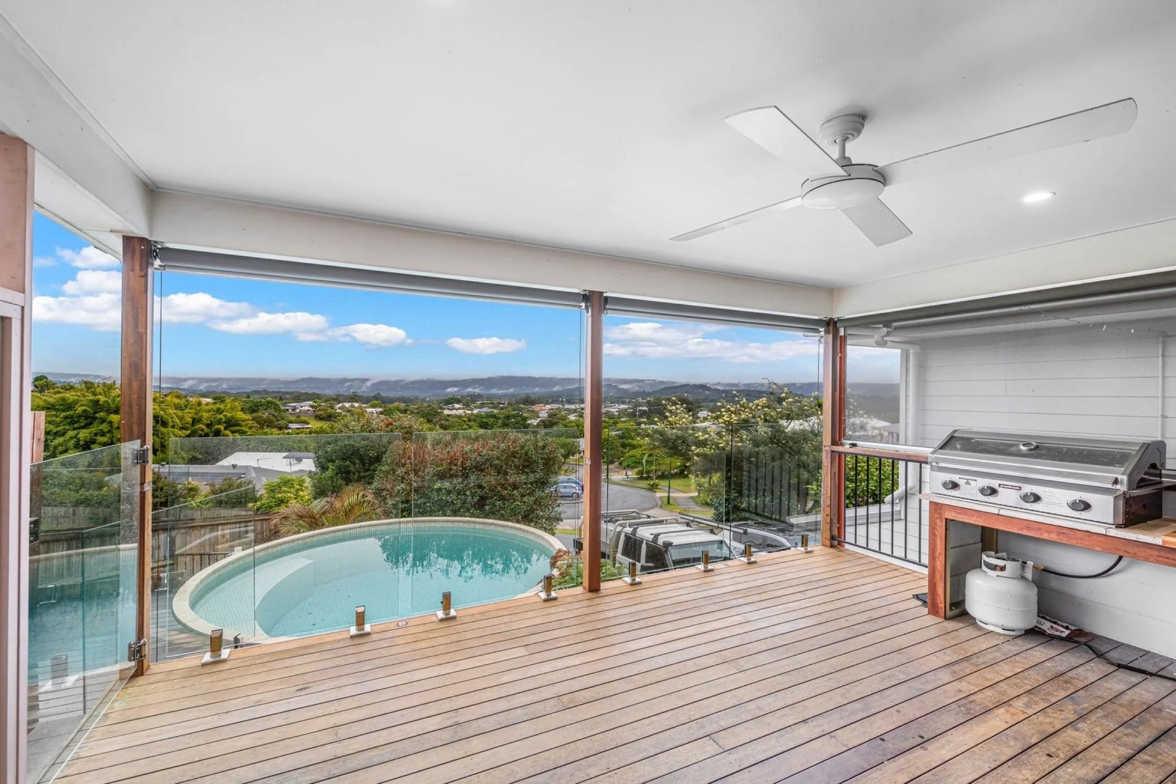 Round plunge pool on an elevated timber deck, seen from a covered balcony