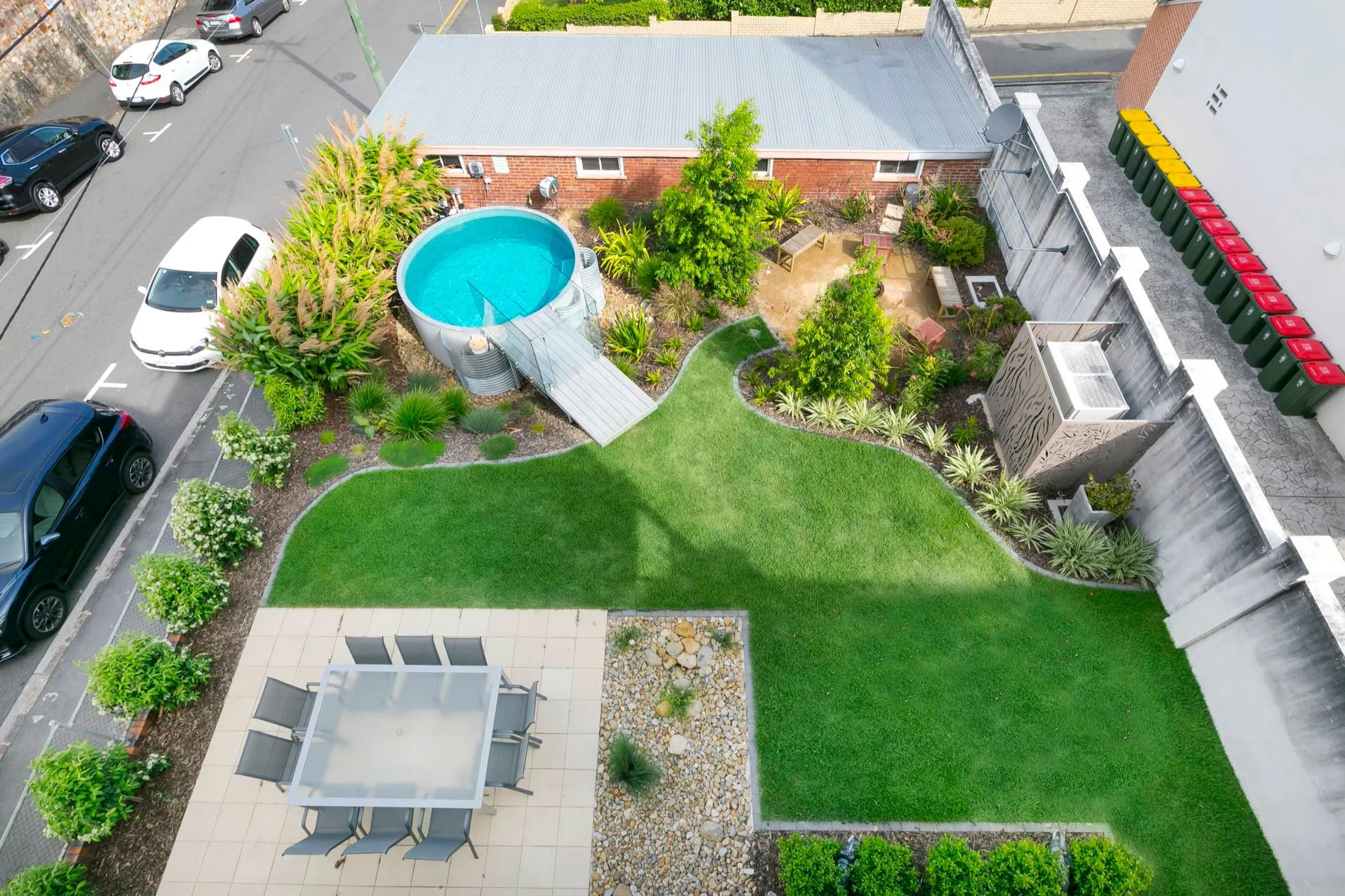 Aerial view of a round plunge pool in a landscaped backyard