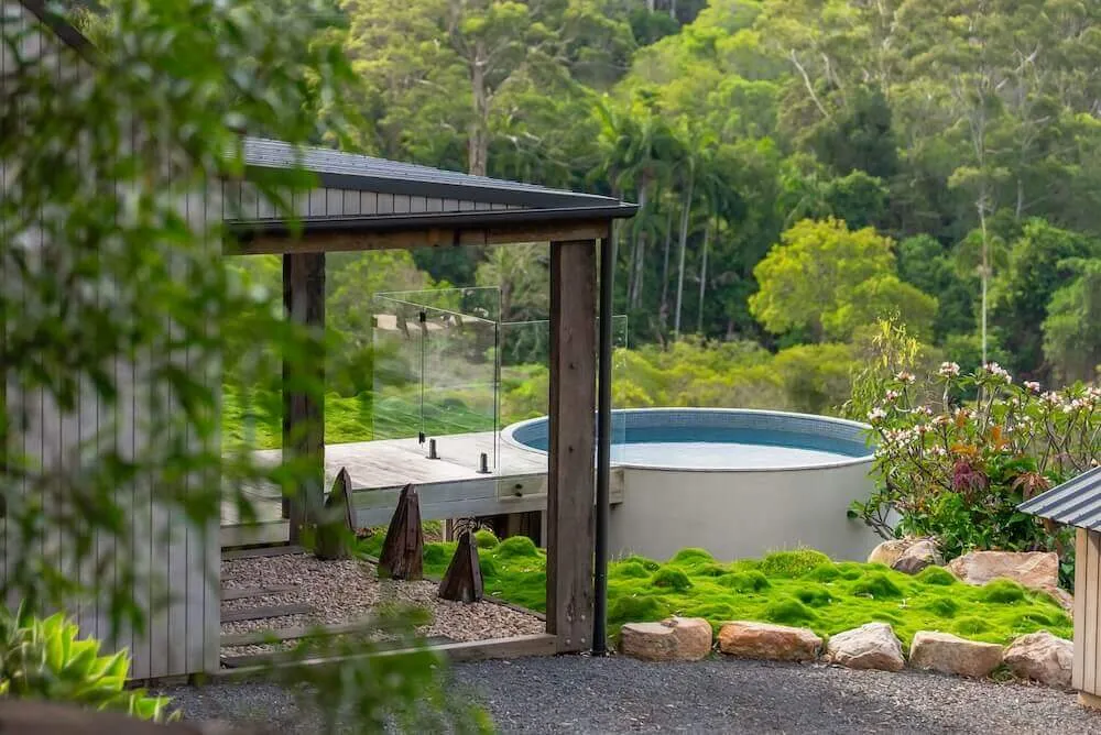 Round plunge pool framed by a timber pavilion and garden