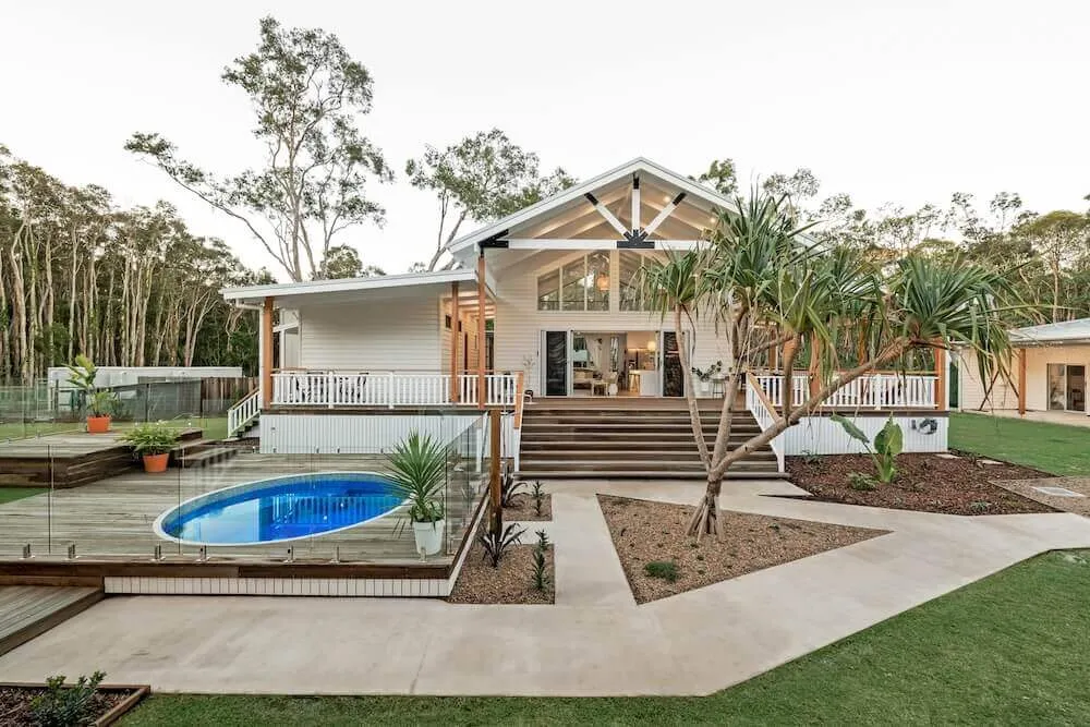 Small round plunge pool in front of a Queenslander-style home